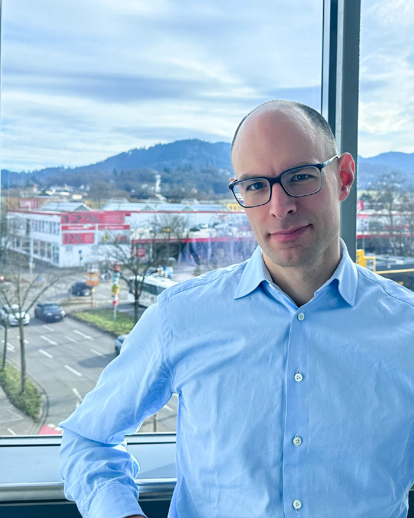 Benjamin Proescholdt im hellblauen Hemd am Fenster.